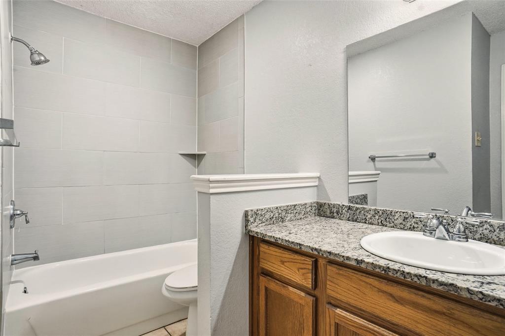 6720 Crestmont Court Fort Worth, TX 76133 - Photo 14 of 16 a bathroom with a granite countertop sink toilet and shower