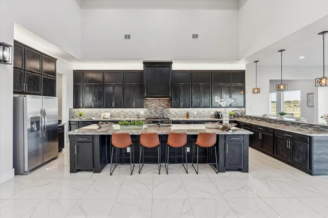 a large kitchen with kitchen island a sink table and chairs