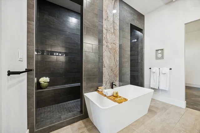 a bathroom with a tub a sink and shower