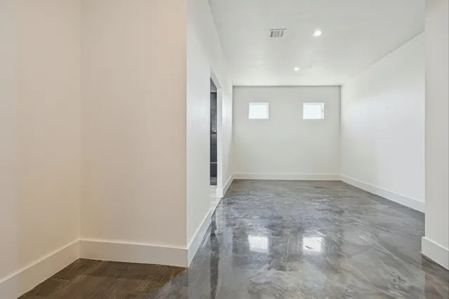 a view of a big room with wooden floor and windows