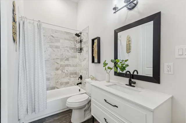 a bathroom with a sink a toilet a mirror and shower