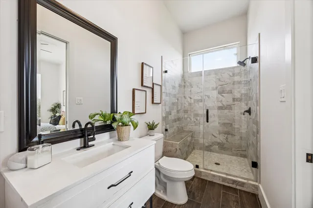 a bathroom with a double vanity sink toilet and shower