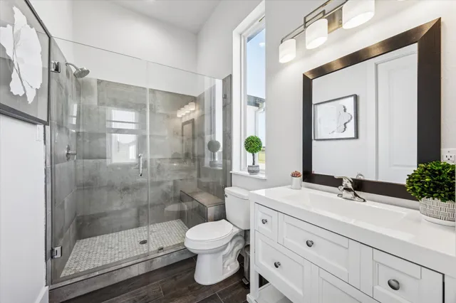 a bathroom with a sink a toilet and shower