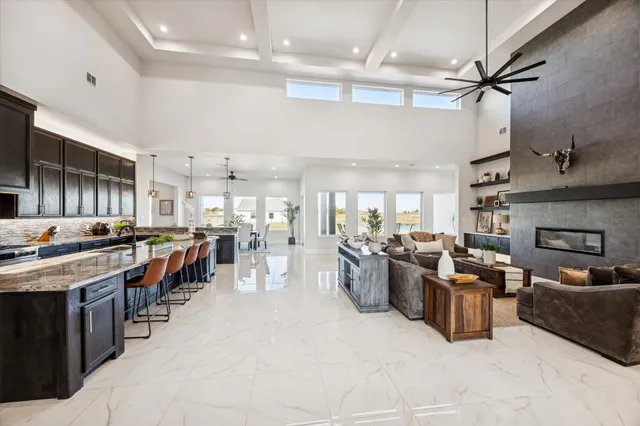 a large white kitchen with lots of counter space a sink a stove and furniture