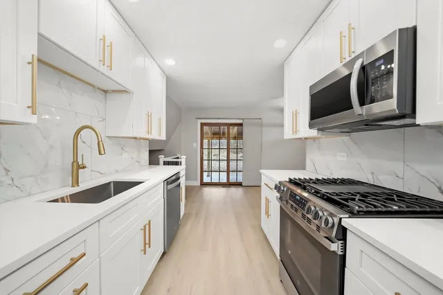 a kitchen with stainless steel appliances a sink stove and microwave