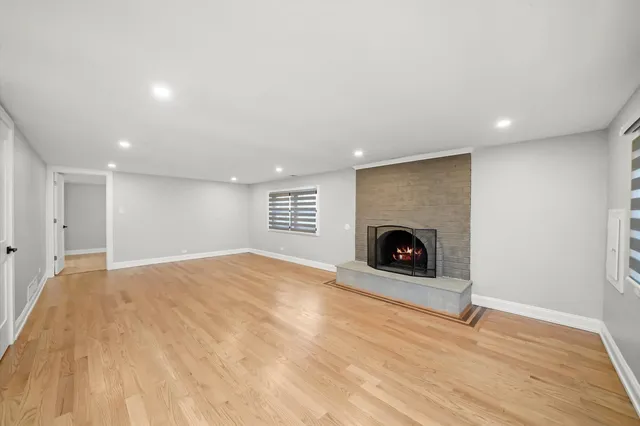 a view of an empty room with a fireplace and a window