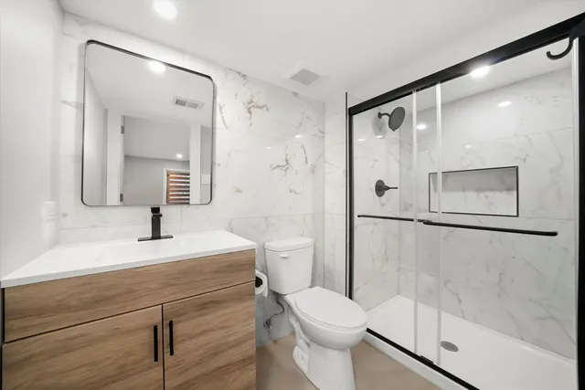 a bathroom with a sink mirror toilet and shower