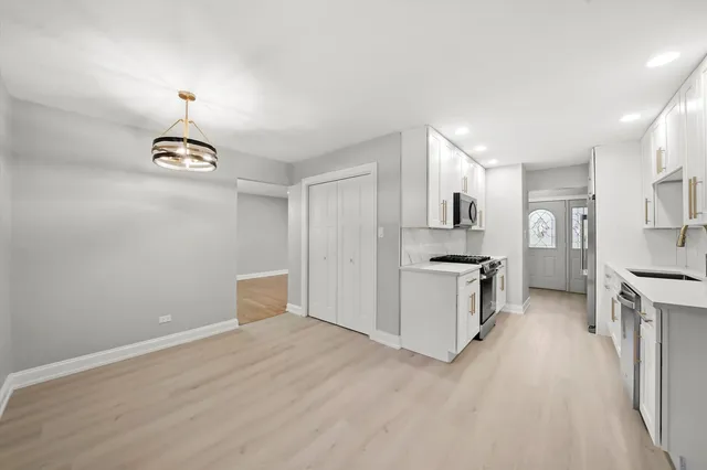 a kitchen with granite countertop a stove a sink and a refrigerator
