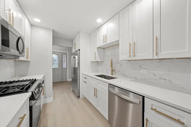 a kitchen with stainless steel appliances white cabinets and a sink