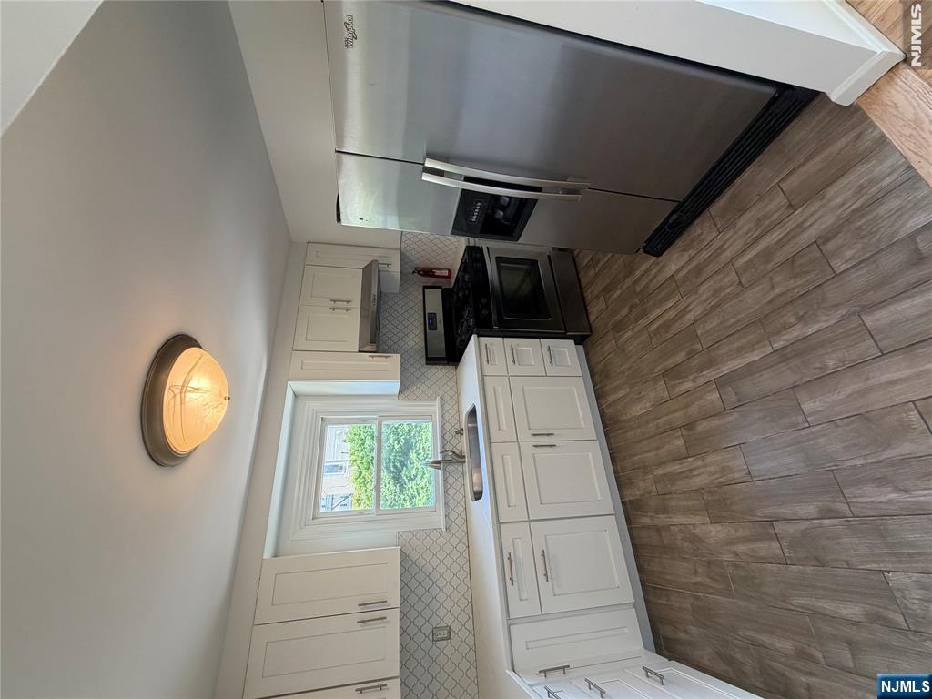 53 Devon Terrace, Unit 2 Kearny, NJ 07032 - Photo 5 of 15 a kitchen with a sink a window and stainless steel appliances