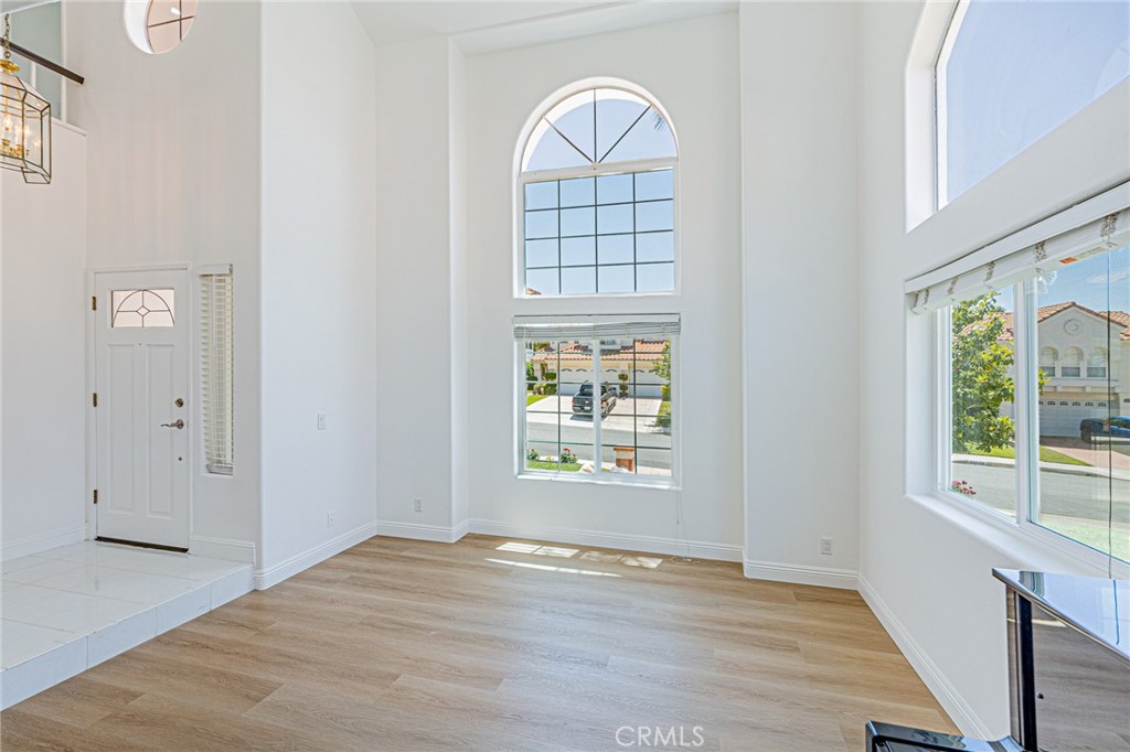 25533 Longfellow Place Stevenson Ranch, CA 91381 - Photo 3 of 47 an empty room with wooden floor windows and exposed bricks