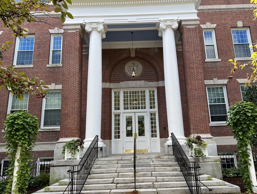 a view of a brick house with many windows