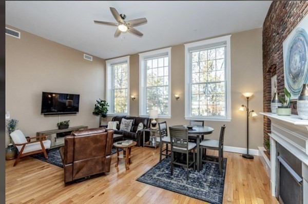 52 Sanborn Street, Unit 102 Reading, MA 01867 - Photo 11 of 28 a living room with furniture a large window and a dining table