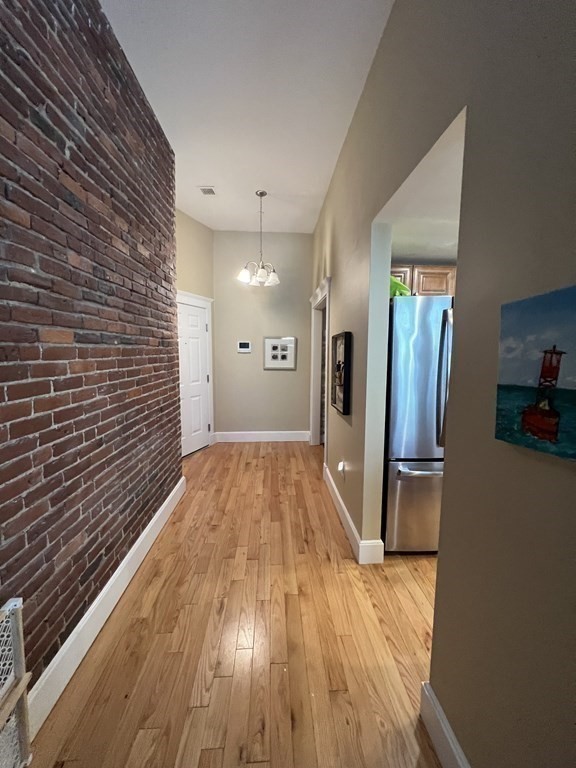 52 Sanborn Street, Unit 102 Reading, MA 01867 - Photo 12 of 28 a view of a hallway with wooden floor and staircase