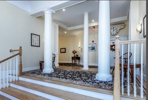 52 Sanborn Street, Unit 102 Reading, MA 01867 - Photo 2 of 28 a view of a hallway with wooden floor and staircase