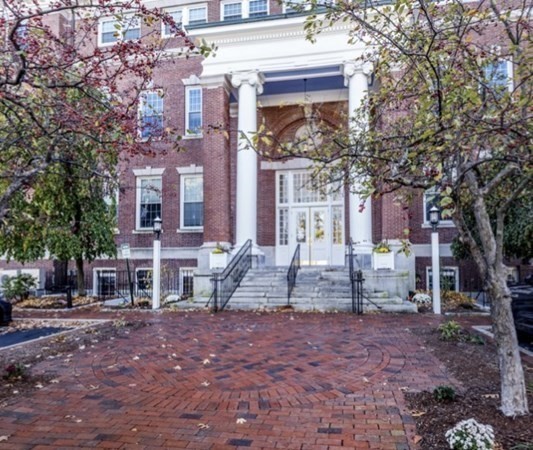 52 Sanborn Street, Unit 102 Reading, MA 01867 - Photo 27 of 28 a front view of a building with large trees