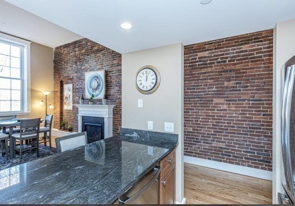 52 Sanborn Street, Unit 102 Reading, MA 01867 - Photo 5 of 28 a view of a kitchen with a fridge and cabinets