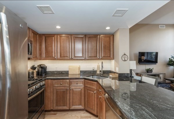 52 Sanborn Street, Unit 102 Reading, MA 01867 - Photo 10 of 28 a kitchen with stainless steel appliances granite countertop a sink stove and cabinets