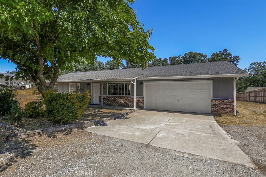 front view of a house with a bench and trees