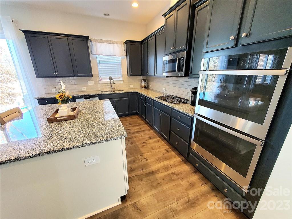 10013 Sunset Ridge Midland, NC 28107 - Photo 11 of 45 a kitchen with stainless steel appliances granite countertop a stove microwave and sink