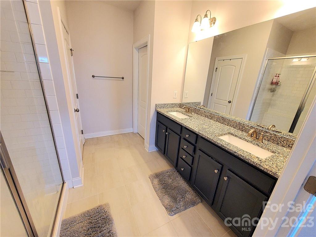 10013 Sunset Ridge Midland, NC 28107 - Photo 39 of 45 a bathroom with a granite countertop sink a mirror and a shower