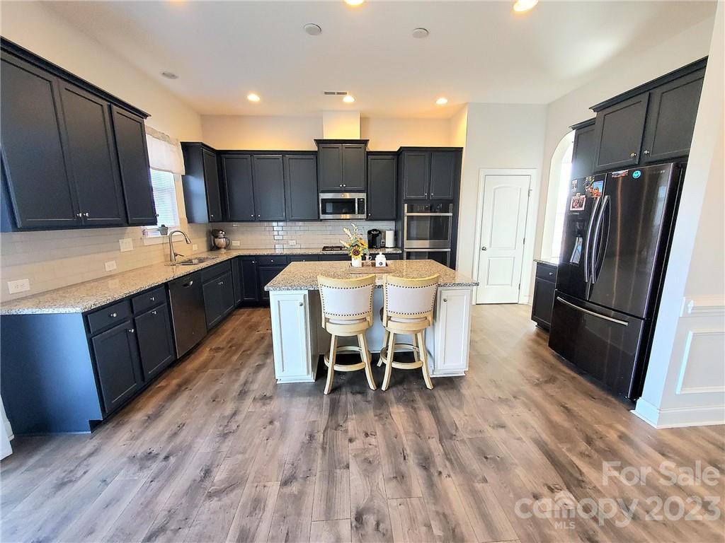 10013 Sunset Ridge Midland, NC 28107 - Photo 10 of 45 a kitchen with stainless steel appliances a dining table chairs stove refrigerator and cabinets
