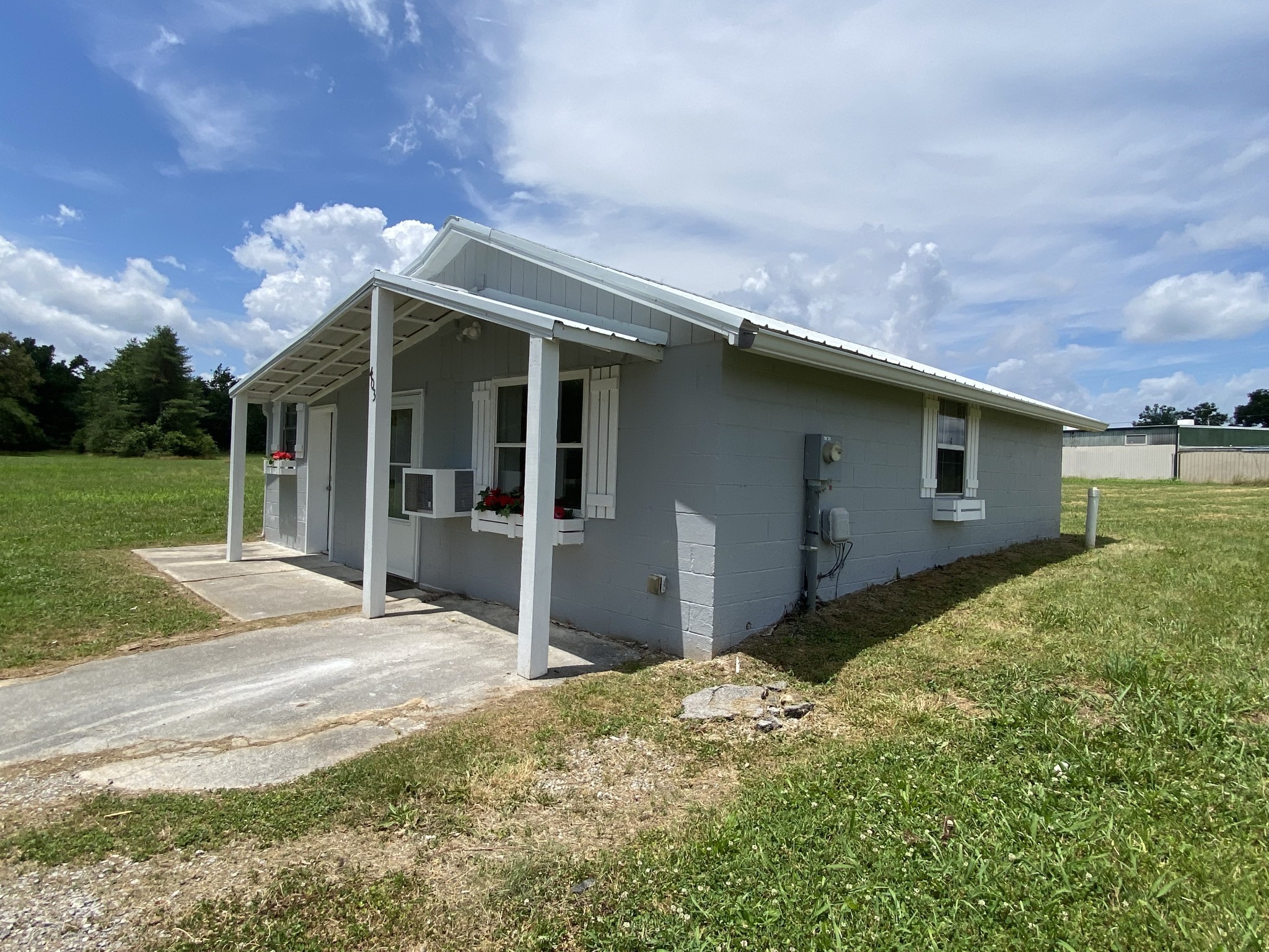 401 Whaley Street Smithville, TN 37166 - Photo 18 of 38 a backyard of a house with large trees and a yard