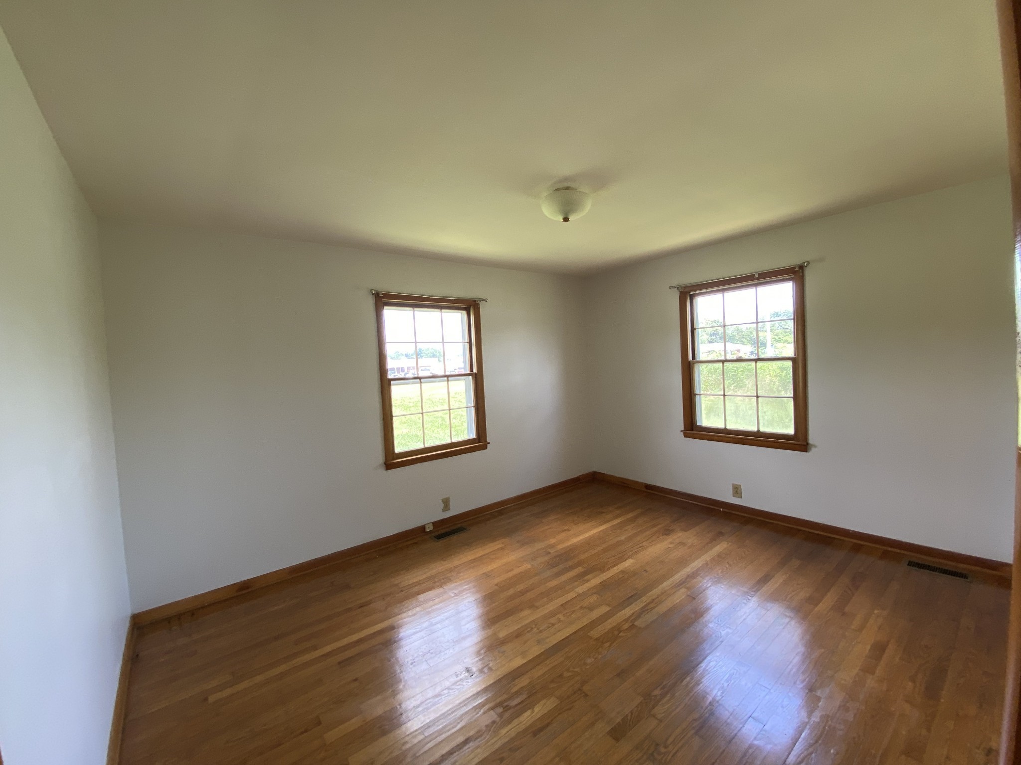 401 Whaley Street Smithville, TN 37166 - Photo 4 of 38 an empty room with wooden floor and windows