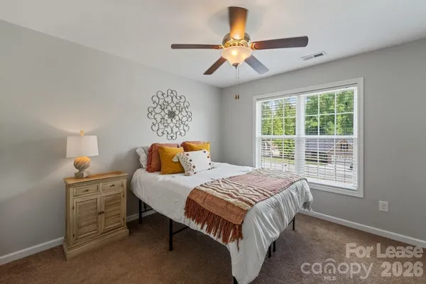 a bedroom with a bed chandelier and a window