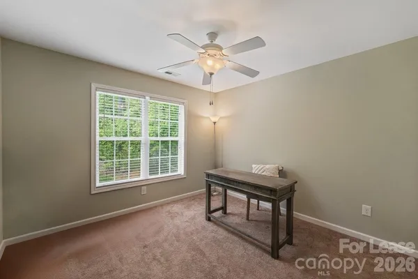 a view of a workspace with furniture and a window
