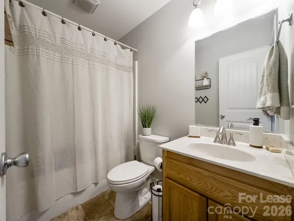 a bathroom with a sink a toilet and shower curtain