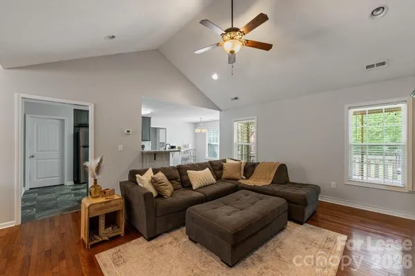 a living room with furniture a ceiling fan and a window