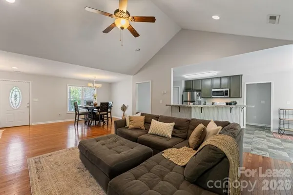 a living room with furniture and a view of kitchen