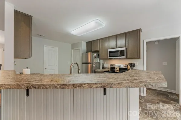 a kitchen with stainless steel appliances granite countertop a sink refrigerator and microwave