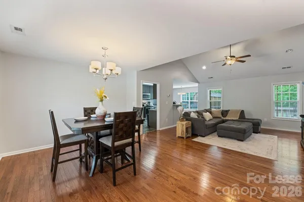 a living room with furniture a dining table and wooden floor