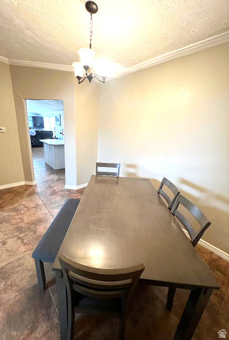 1407 North 1250th Street West Helper, UT 84526 - Photo 12 of 27 Dining area featuring a textured ceiling, ornamental molding, and hanging lights