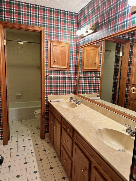 408 Myra Street Mansfield, LA 71052 - Photo 16 of 16 Full bathroom featuring a textured ceiling, tile patterned floors, separate shower and tub, vanity, and toilet