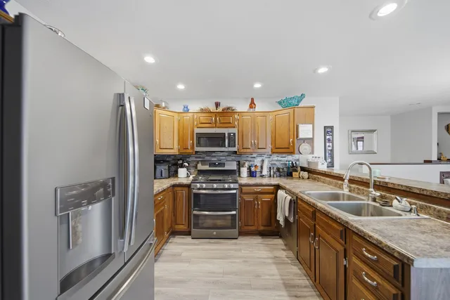 a kitchen with granite countertop a sink stainless steel appliances and cabinets