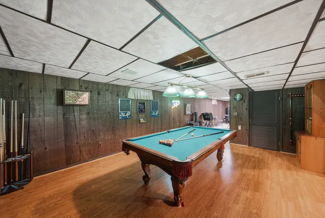 a room with pool table and windows