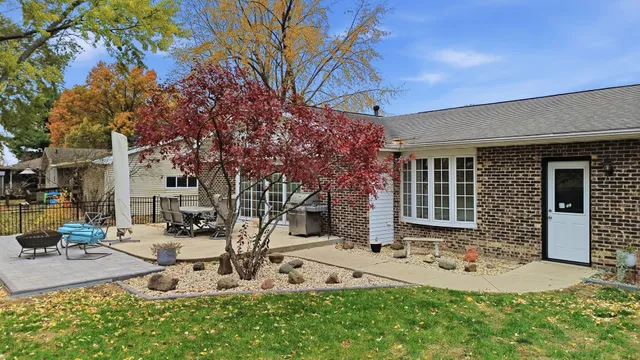 a view of a house with patio chairs and a fire pit