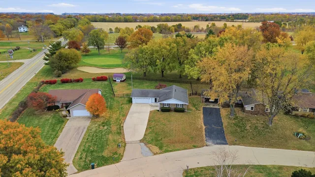 an aerial view of a house with a garden and lake view