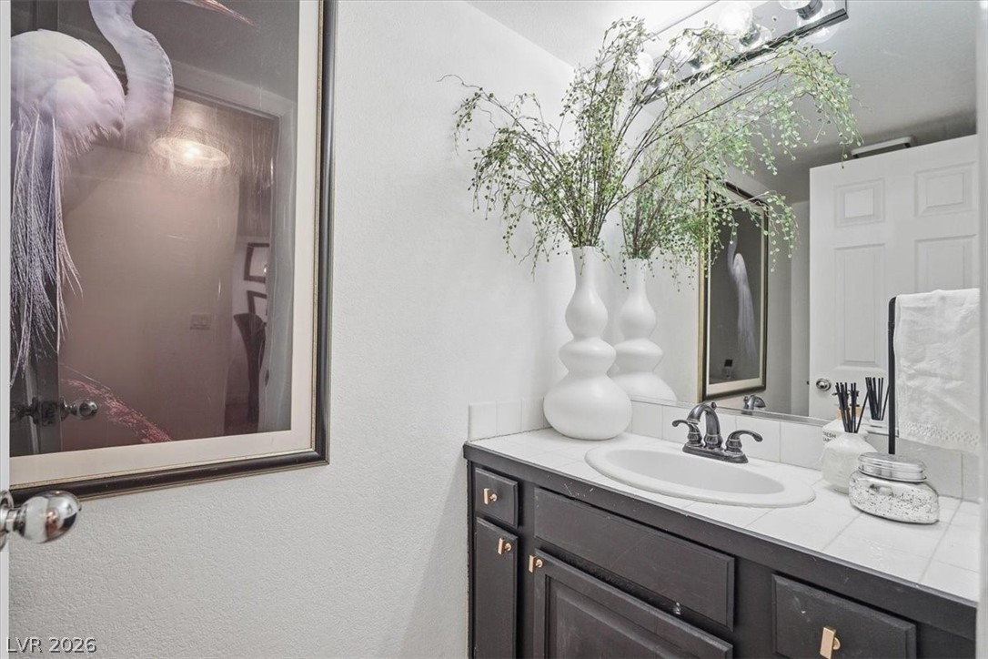 6250 West Flamingo Road, Unit 93 Las Vegas, NV 89103 - Photo 10 of 38 This bright bathroom features a vanity with a sleek countertop and a large mirror.