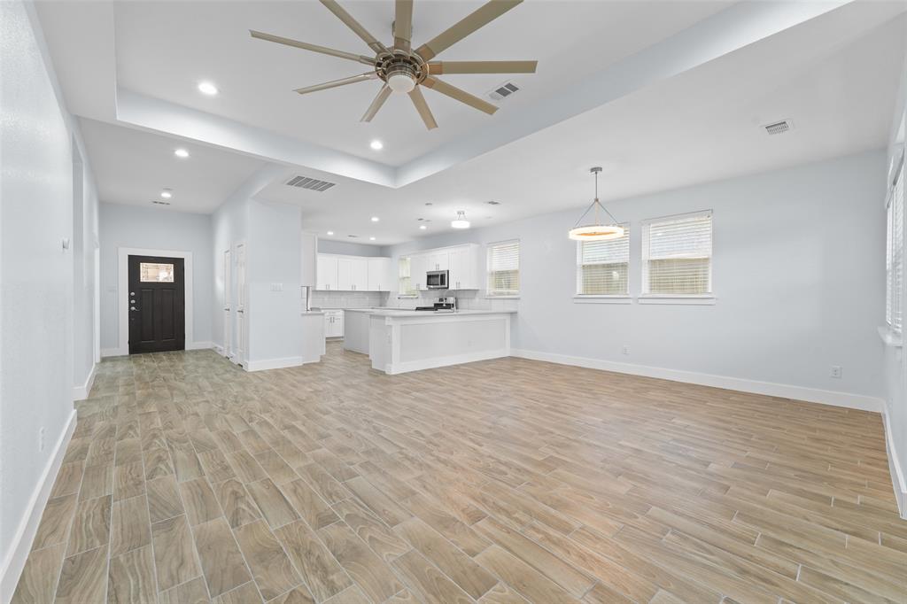 3807 Winding Road Arlington, TX 76016 - Photo 7 of 23 Spacious open-concept living area featuring wood-finish tile flooring, a tray ceiling with a ceiling fan, and recessed lighting
