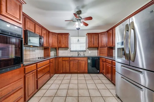 a kitchen with stainless steel appliances granite countertop a stove top oven a sink dishwasher and wooden cabinets