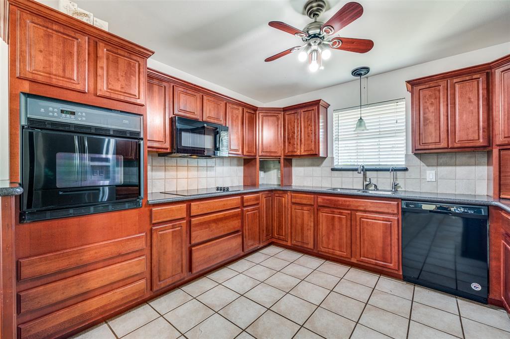 7889 County Road 134 Celina, TX 75009 - Photo 28 of 36 a kitchen with stainless steel appliances granite countertop wooden cabinets a sink and dishwasher