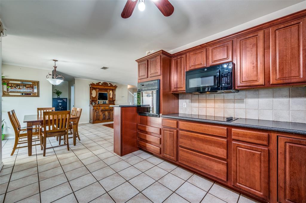 7889 County Road 134 Celina, TX 75009 - Photo 29 of 36 a kitchen with stainless steel appliances granite countertop a stove top oven a sink dishwasher and wooden cabinets
