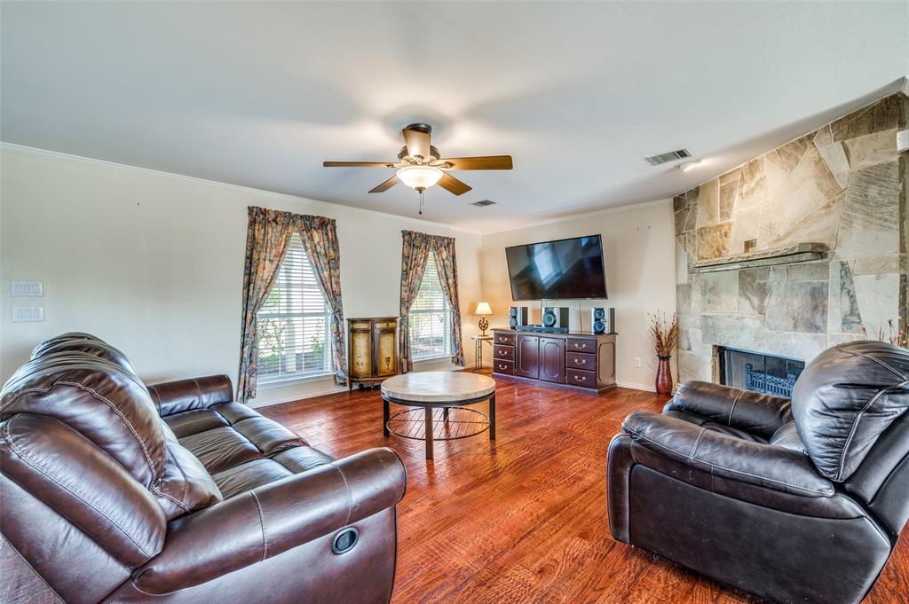 7889 County Road 134 Celina, TX 75009 - Photo 33 of 36 a living room with furniture a fireplace and a flat screen tv