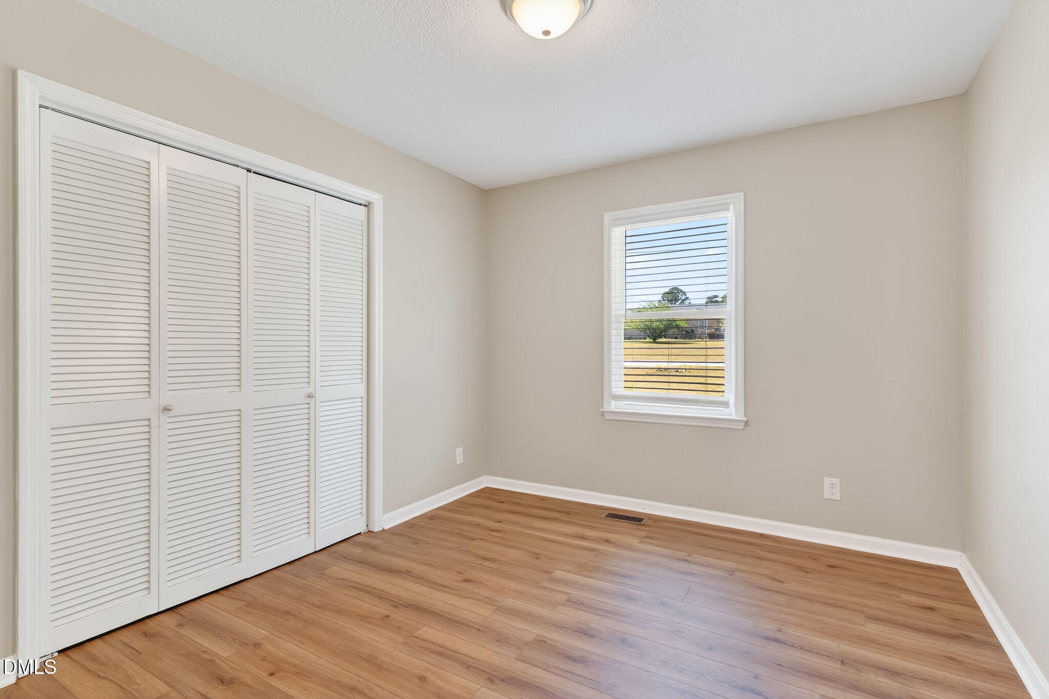 6086 Red Hill Church Road Coats, NC 27521 - Photo 23 of 44 a view of an empty room with wooden floor and a window