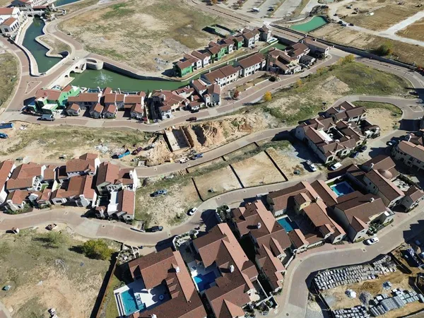 an aerial view of a building with lots of cars and parked cars