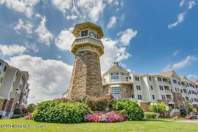 a front view of a multi story residential apartment building with yard and retail shops